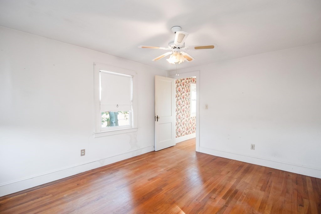 582 Springfield Street Feeding Hills, MA 01030 - Photo 14 of 42 an empty room with wooden floor chandelier fan and windows