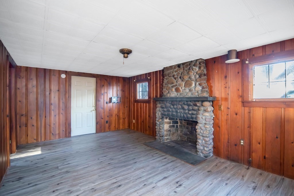 582 Springfield Street Feeding Hills, MA 01030 - Photo 22 of 42 an empty room with wooden floor fireplace and windows