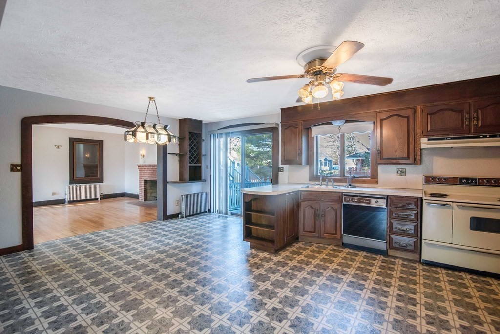 582 Springfield Street Feeding Hills, MA 01030 - Photo 8 of 42 a living room with stainless steel appliances furniture a fireplace and a kitchen view