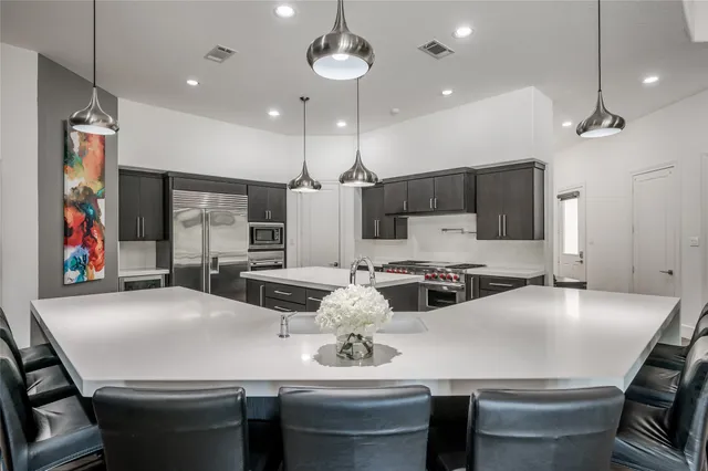 a large kitchen with stainless steel appliances a large counter top