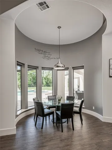 a view of a hallway with wooden floor and dining room