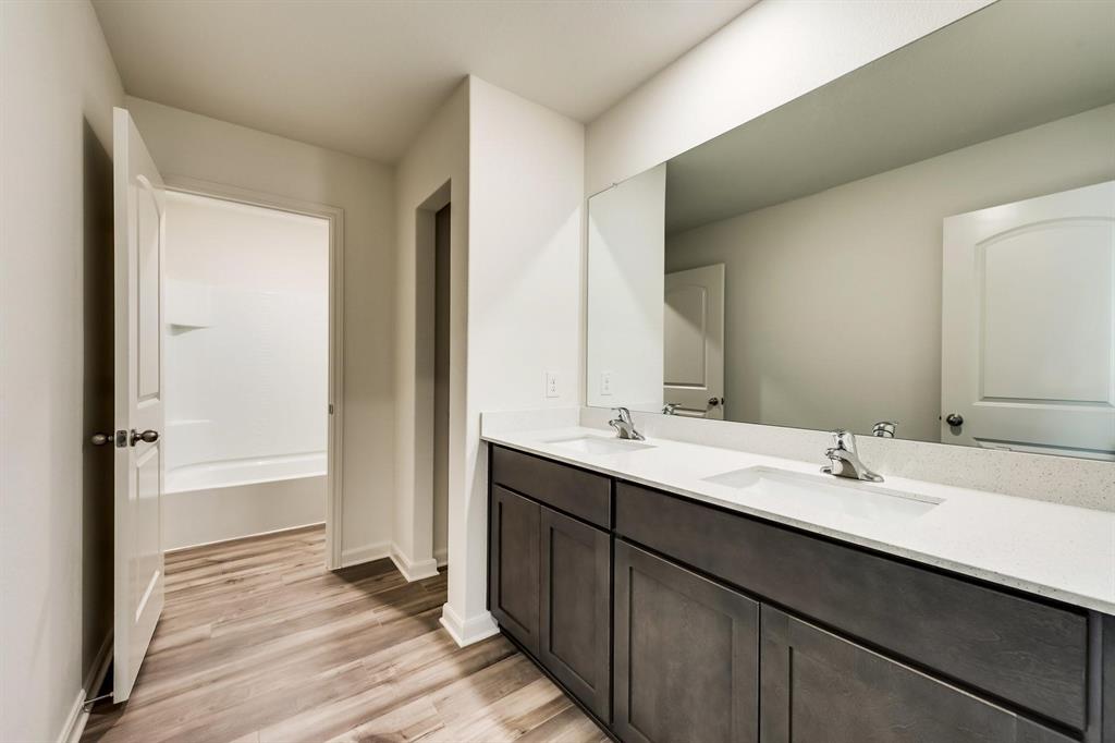8126 Big Timber Trail Ponder, TX 76259 - Photo 12 of 16 a bathroom with a double vanity sink and mirror