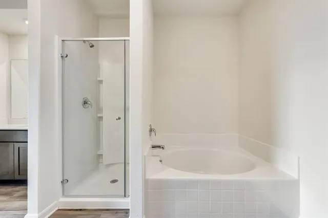 a white bath tub sitting next to a shower