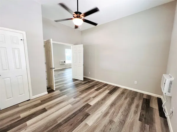 a view of a livingroom with wooden floor and a ceiling fan