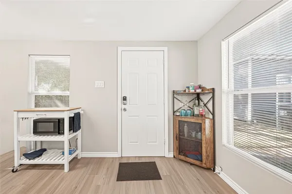 a view of an empty room with a window and wooden floor