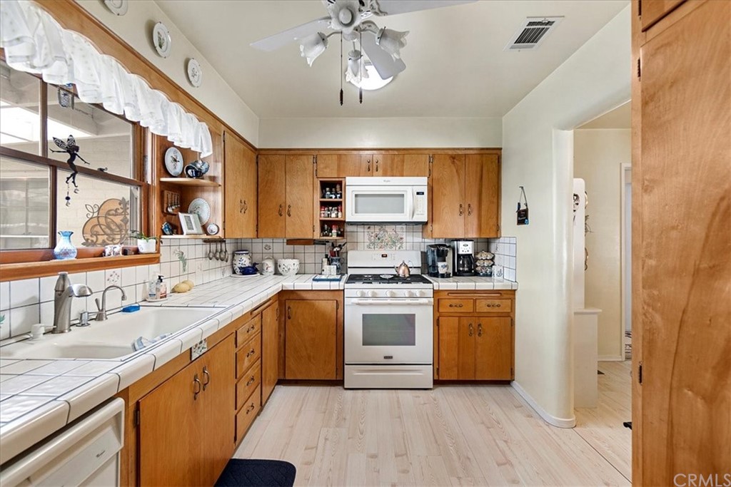 876 North 1st Avenue Upland, CA 91786 - Photo 6 of 30 a kitchen with stainless steel appliances granite countertop a sink cabinets and wooden floor