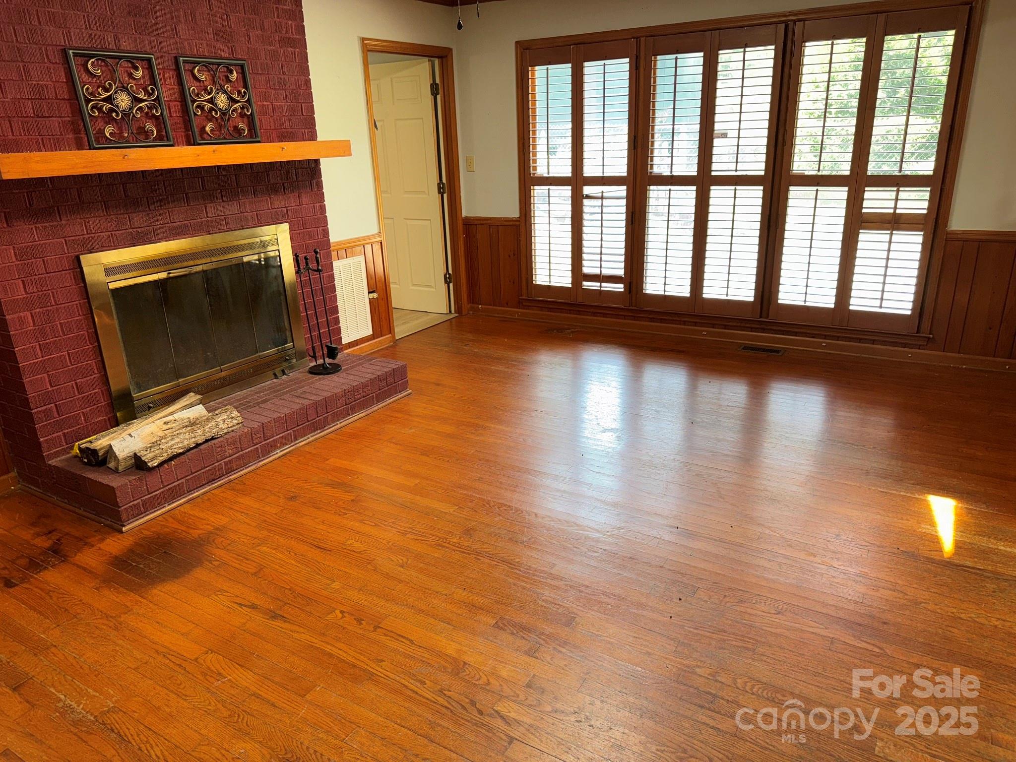 802 Roberdell Road Rockingham, NC 28379 - Photo 12 of 43 a view of an empty room with wooden floor and a fireplace