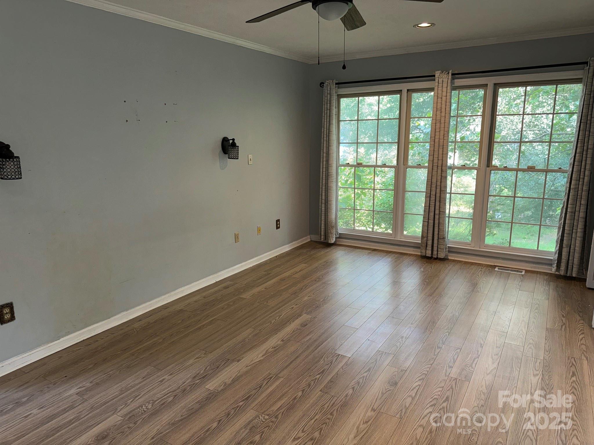 802 Roberdell Road Rockingham, NC 28379 - Photo 21 of 43 an empty room with wooden floor and windows