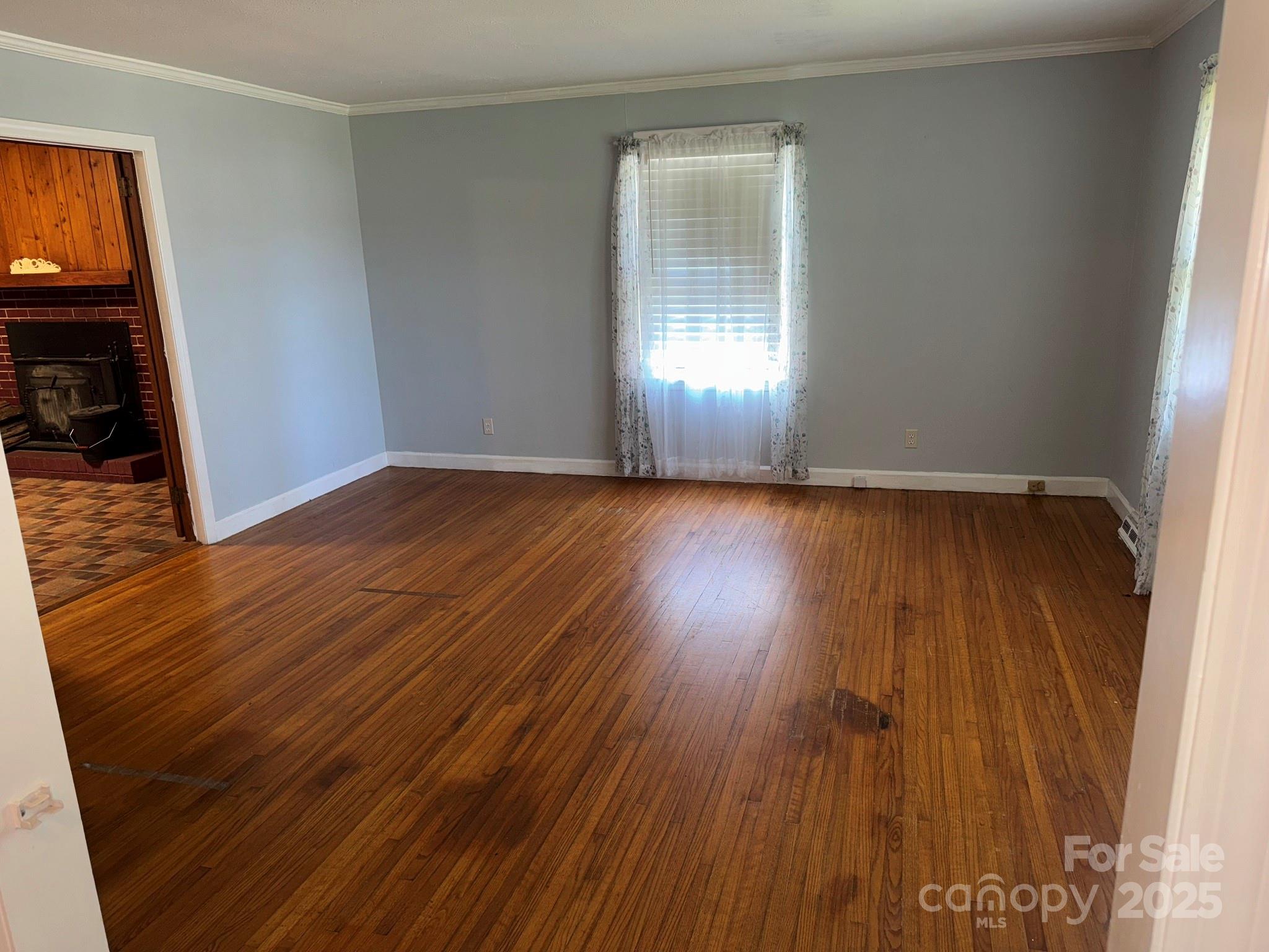 802 Roberdell Road Rockingham, NC 28379 - Photo 22 of 43 an empty room with wooden floor and windows