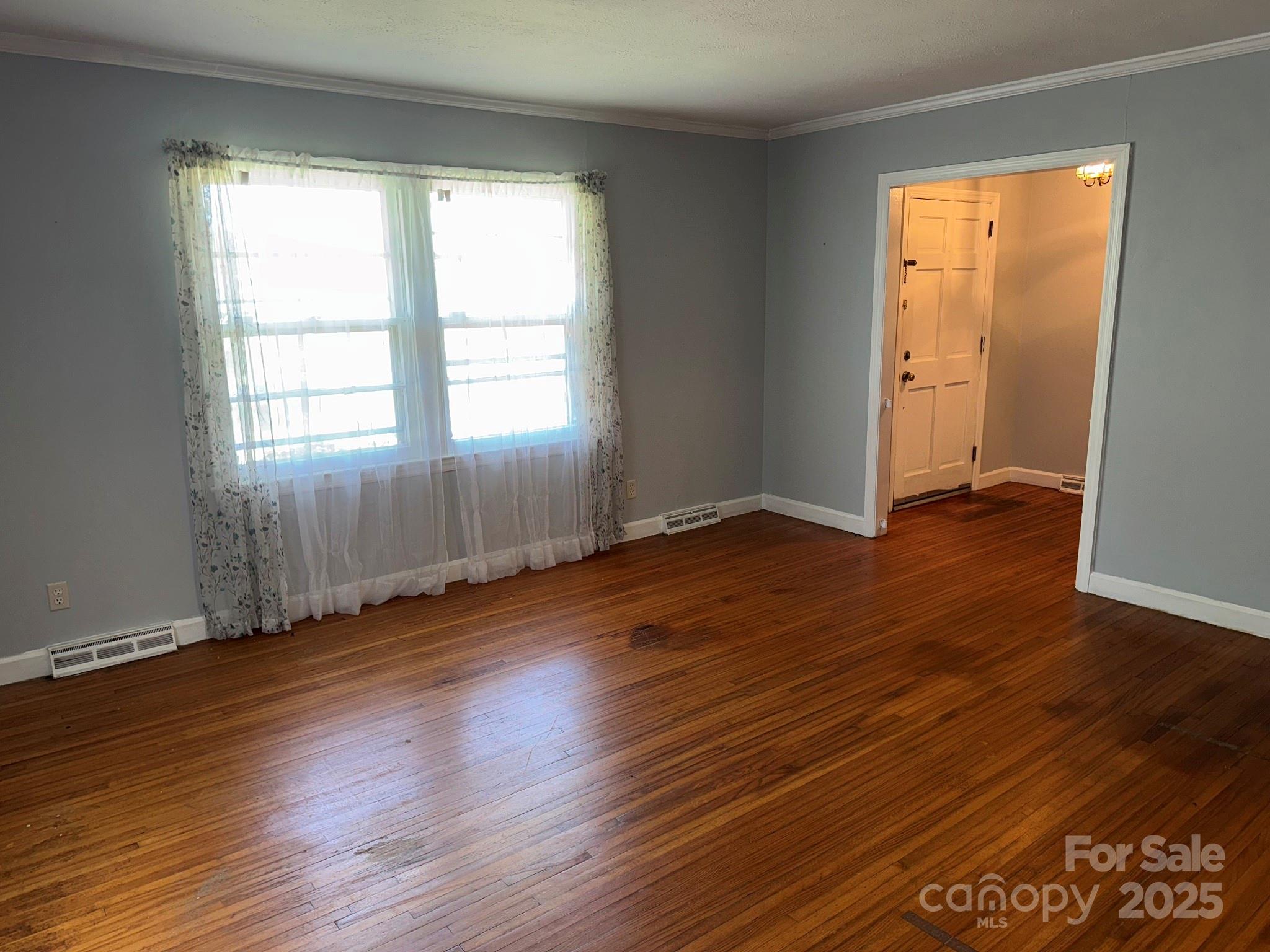 802 Roberdell Road Rockingham, NC 28379 - Photo 23 of 43 an empty room with wooden floor and windows