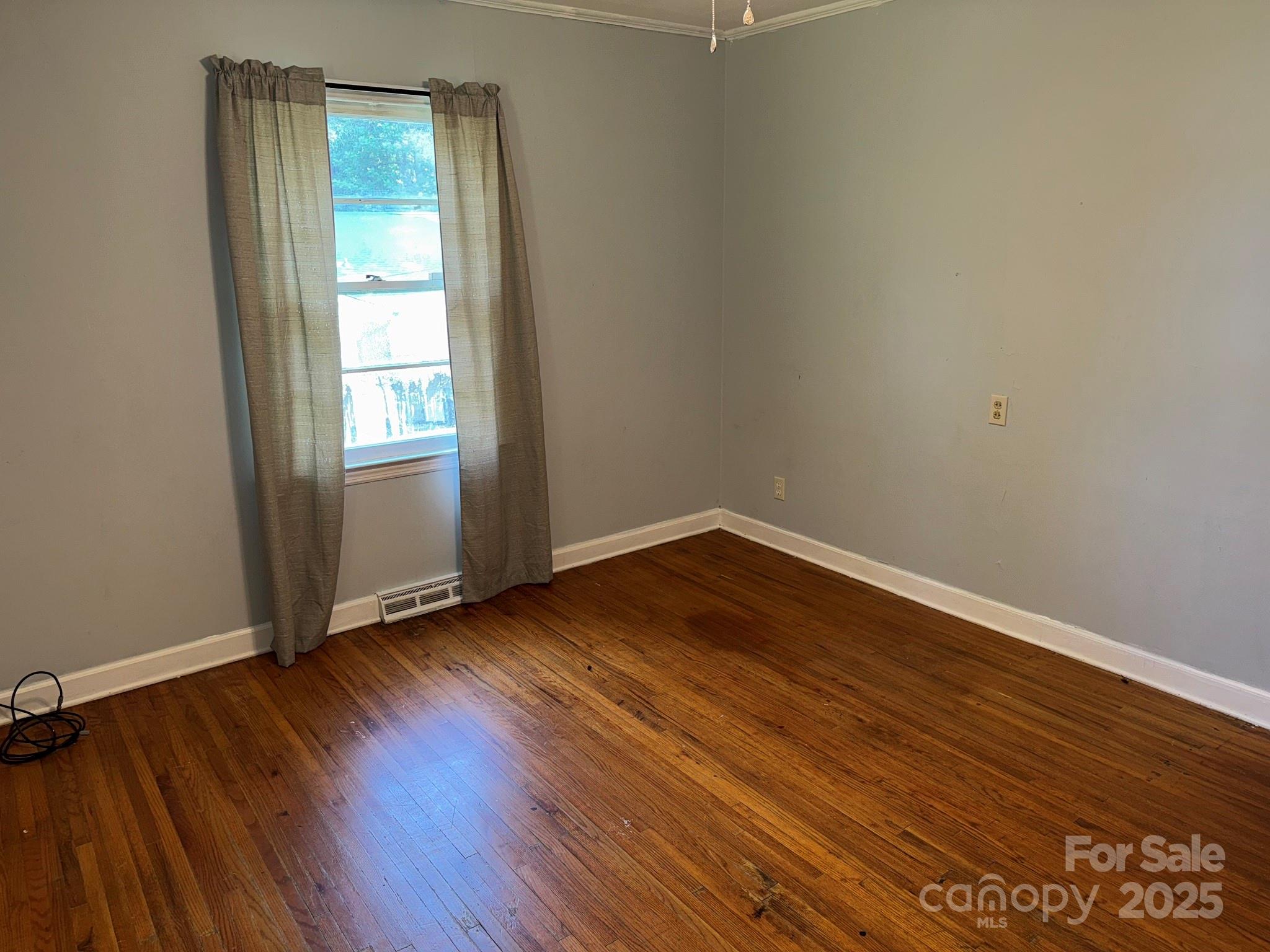 802 Roberdell Road Rockingham, NC 28379 - Photo 28 of 43 an empty room with wooden floor and windows