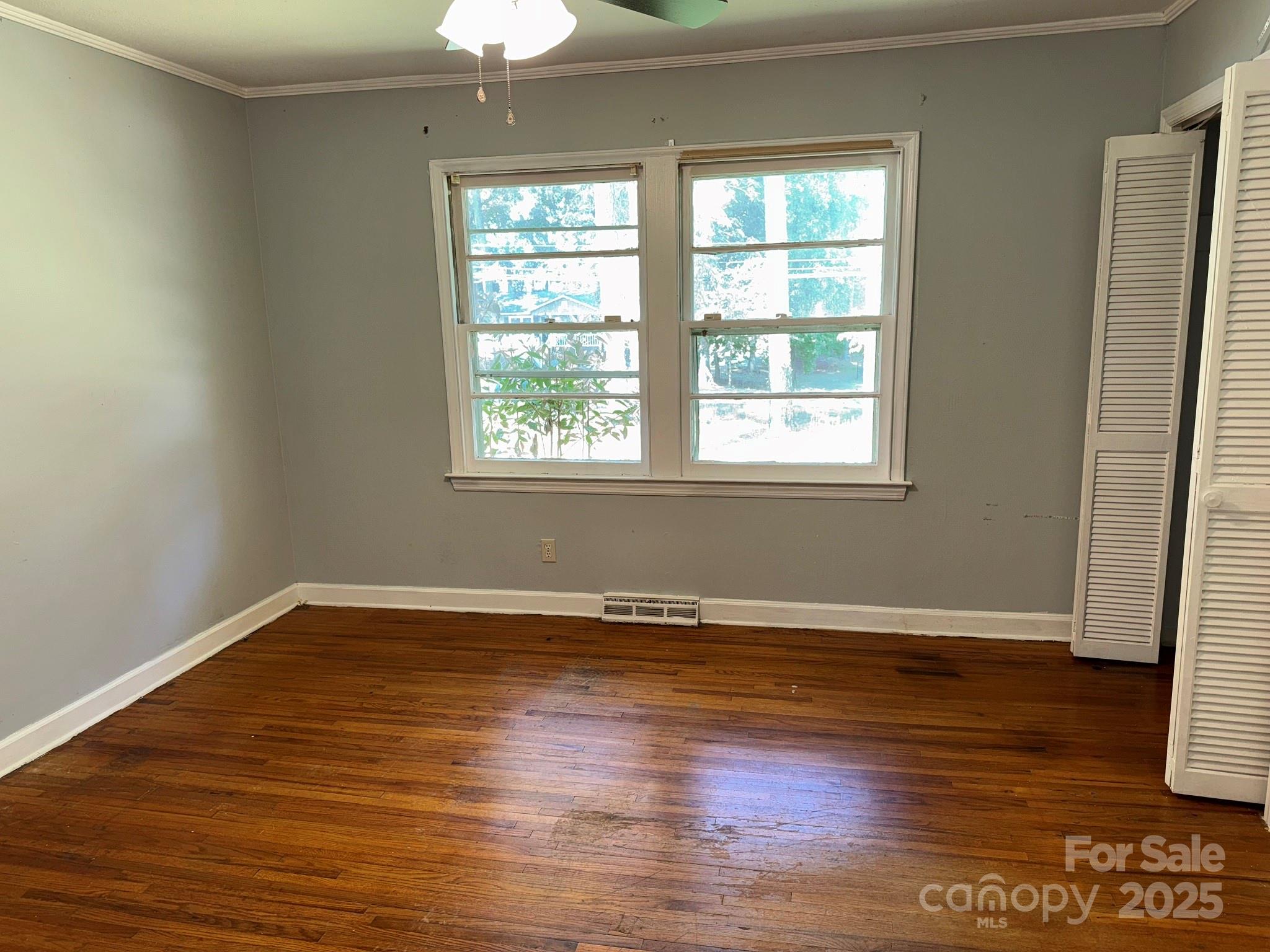 802 Roberdell Road Rockingham, NC 28379 - Photo 35 of 43 an empty room with wooden floor and windows