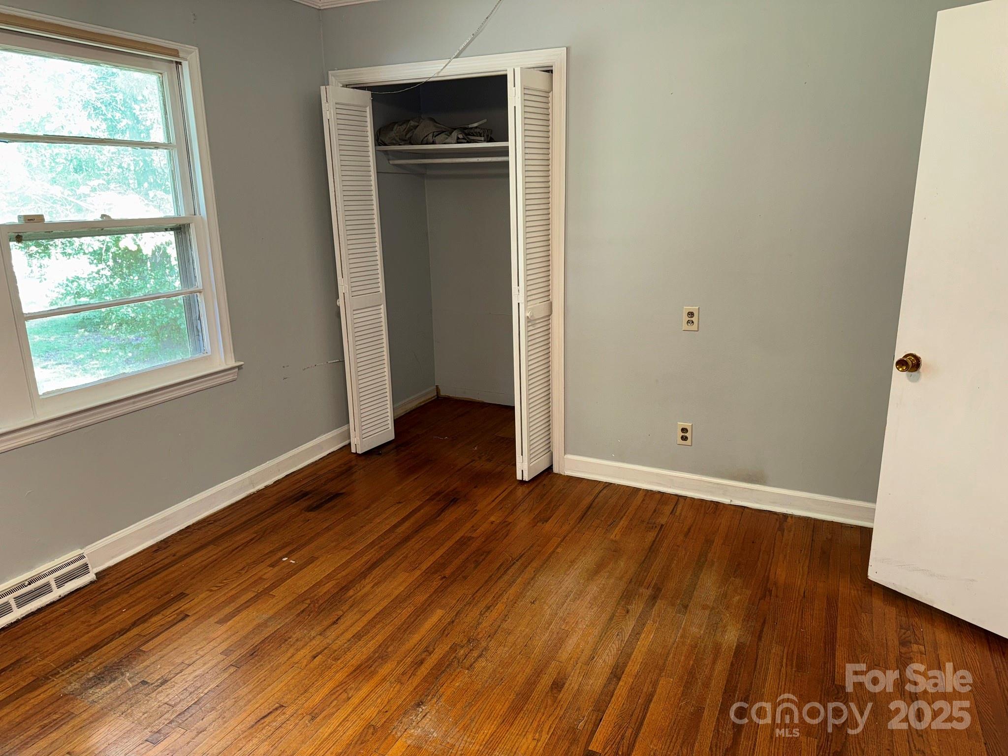 802 Roberdell Road Rockingham, NC 28379 - Photo 36 of 43 an empty room with wooden floor and windows