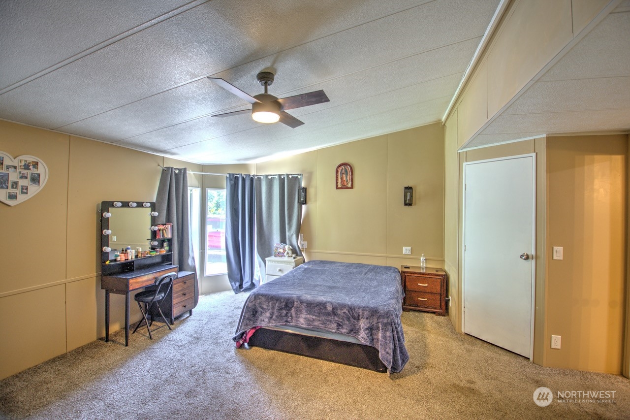 435 Jones Road Winlock, WA 98596 - Photo 6 of 30 a spacious bedroom with a bed and a chandelier