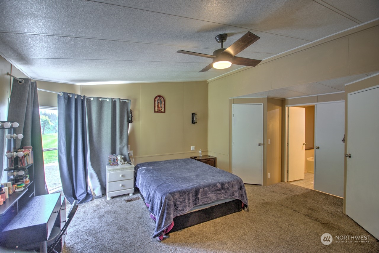 435 Jones Road Winlock, WA 98596 - Photo 7 of 30 a spacious bedroom with a large bed and a chandelier