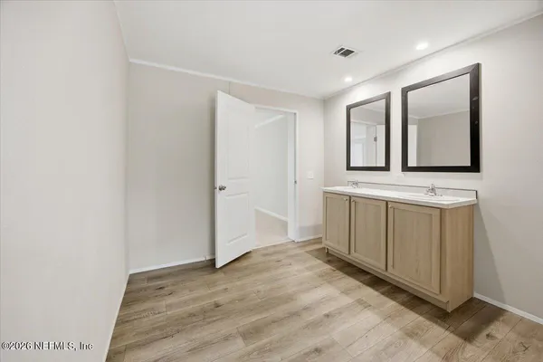 a view of a hallway with bathroom and mirror