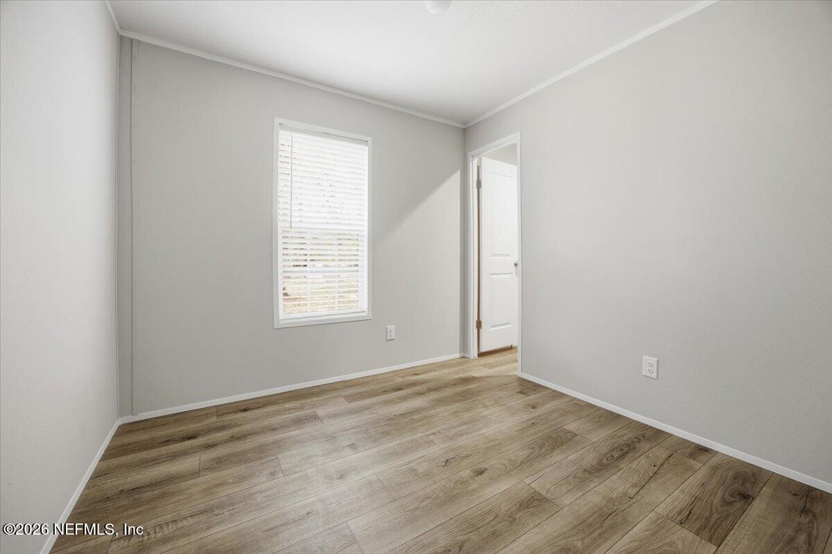 6067 Taft Road Macclenny, FL 32063 - Photo 19 of 23 a view of an empty room with wooden floor and a window