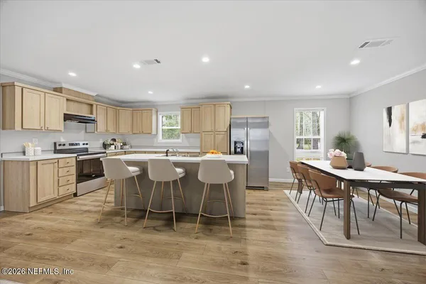 a large kitchen with a table and chairs
