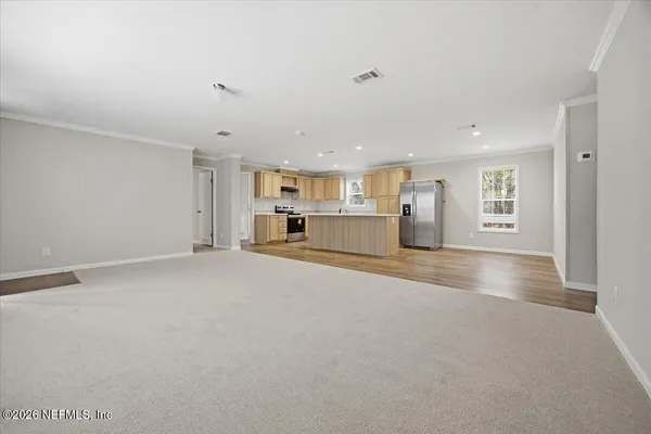 a view of empty room with wooden floor