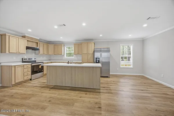 a large kitchen with a center island and stainless steel appliances