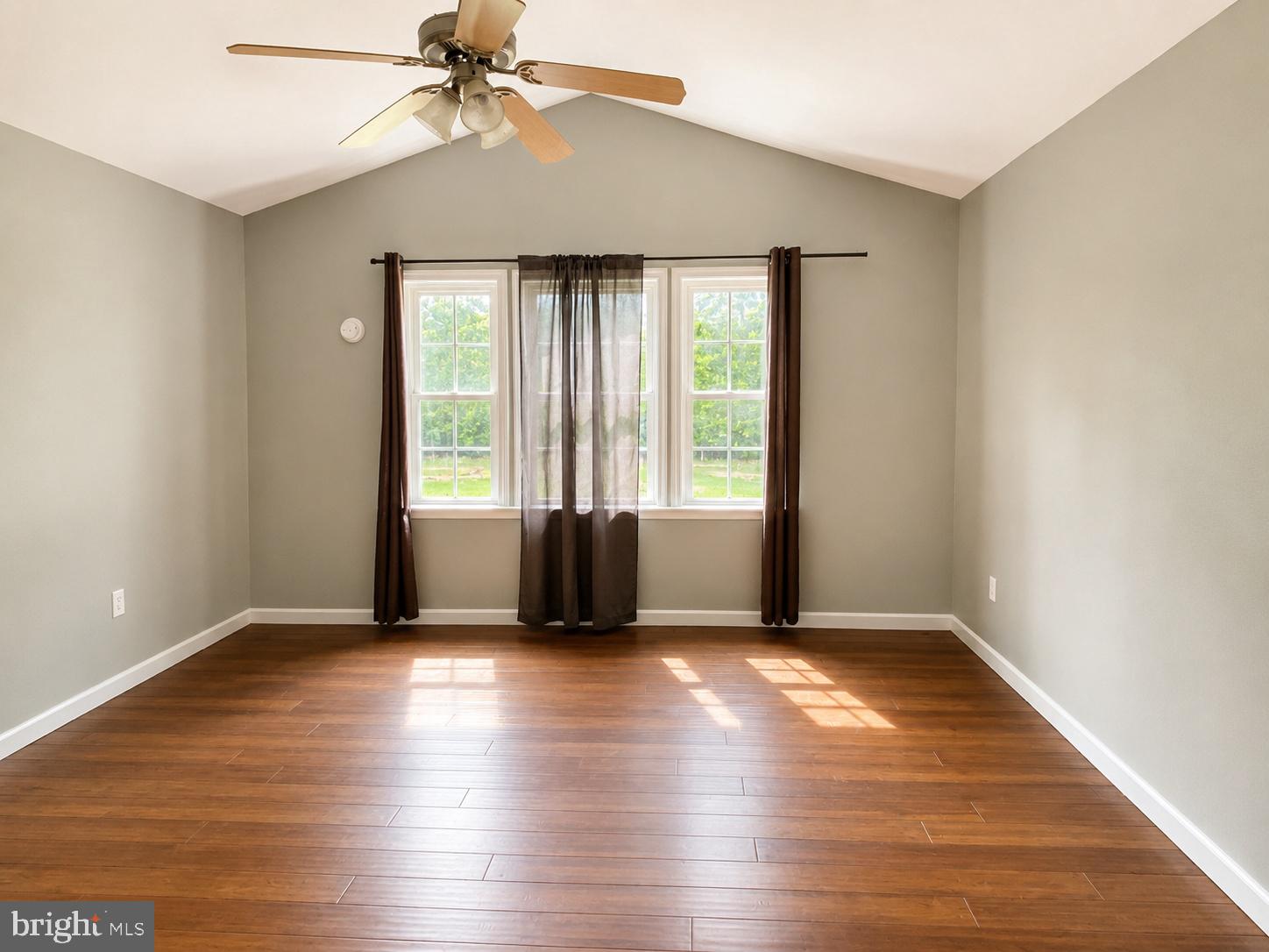 550 Walnut Shade Road Louisa, VA 23093 - Photo 6 of 7 an empty room with wooden floor fan and windows