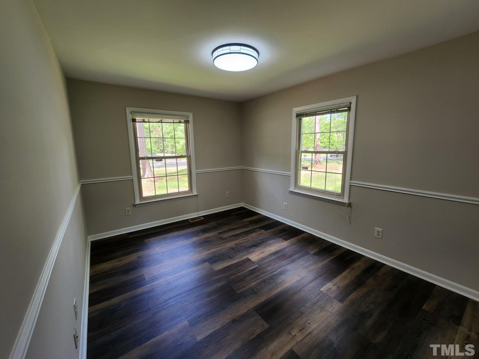 2764 Milburnie Road Raleigh, NC 27610 - Photo 17 of 39 an empty room with wooden floor and windows