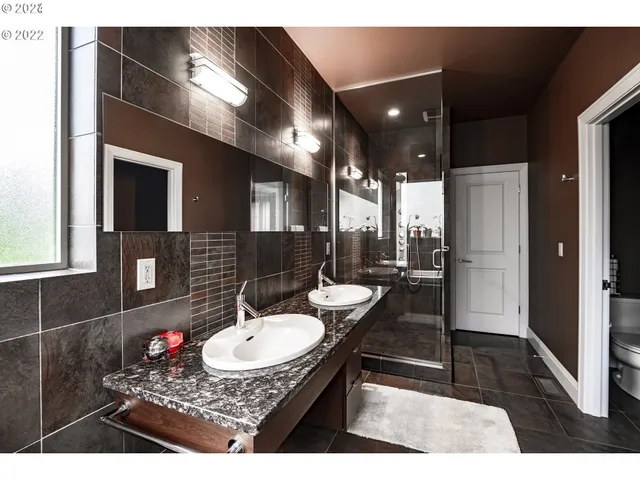 a bathroom with a sink a toilet a mirror and shower