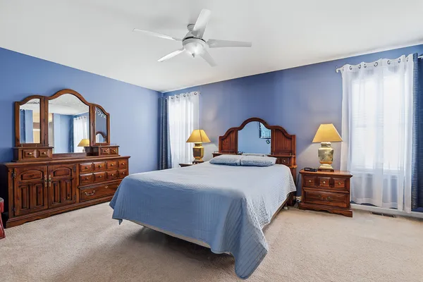 a bedroom with a large bed a chandelier and a window