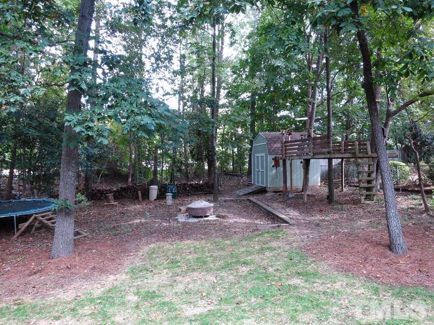 4516 Wingate Drive Raleigh, NC 27609 - Photo 24 of 25 a view of a backyard with table and chairs a fire pit and a large tree