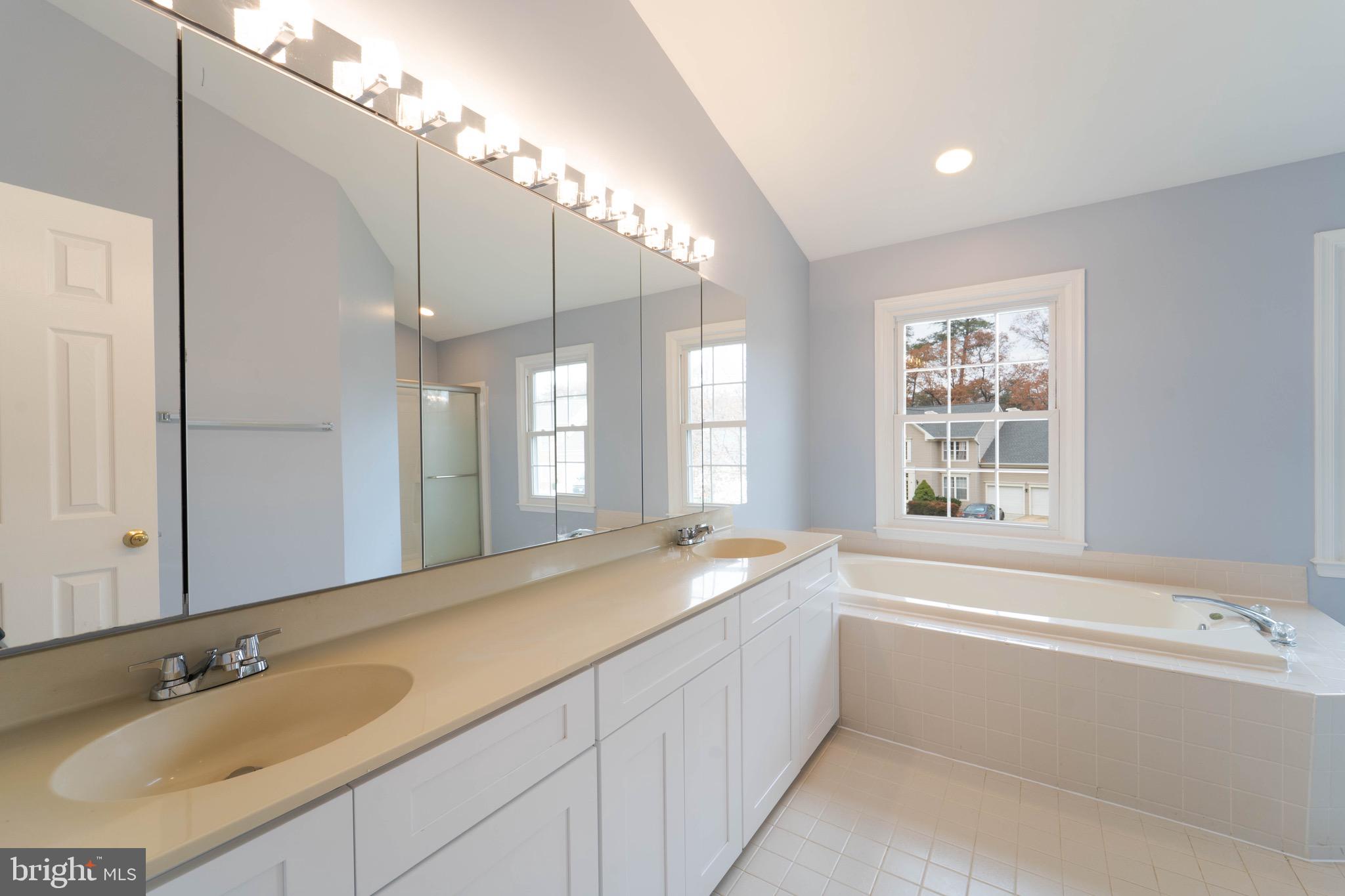 9407 Copernicus Drive Lanham, MD 20706 - Photo 30 of 48 a spacious bathroom with a granite countertop tub sink and mirror