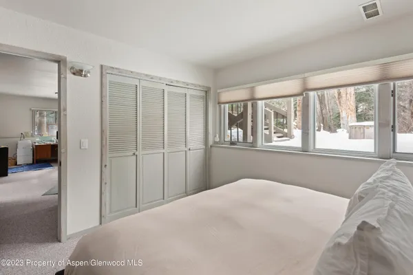 a bedroom with a bed and a large window