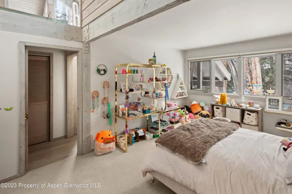 a bedroom with bed and a large window