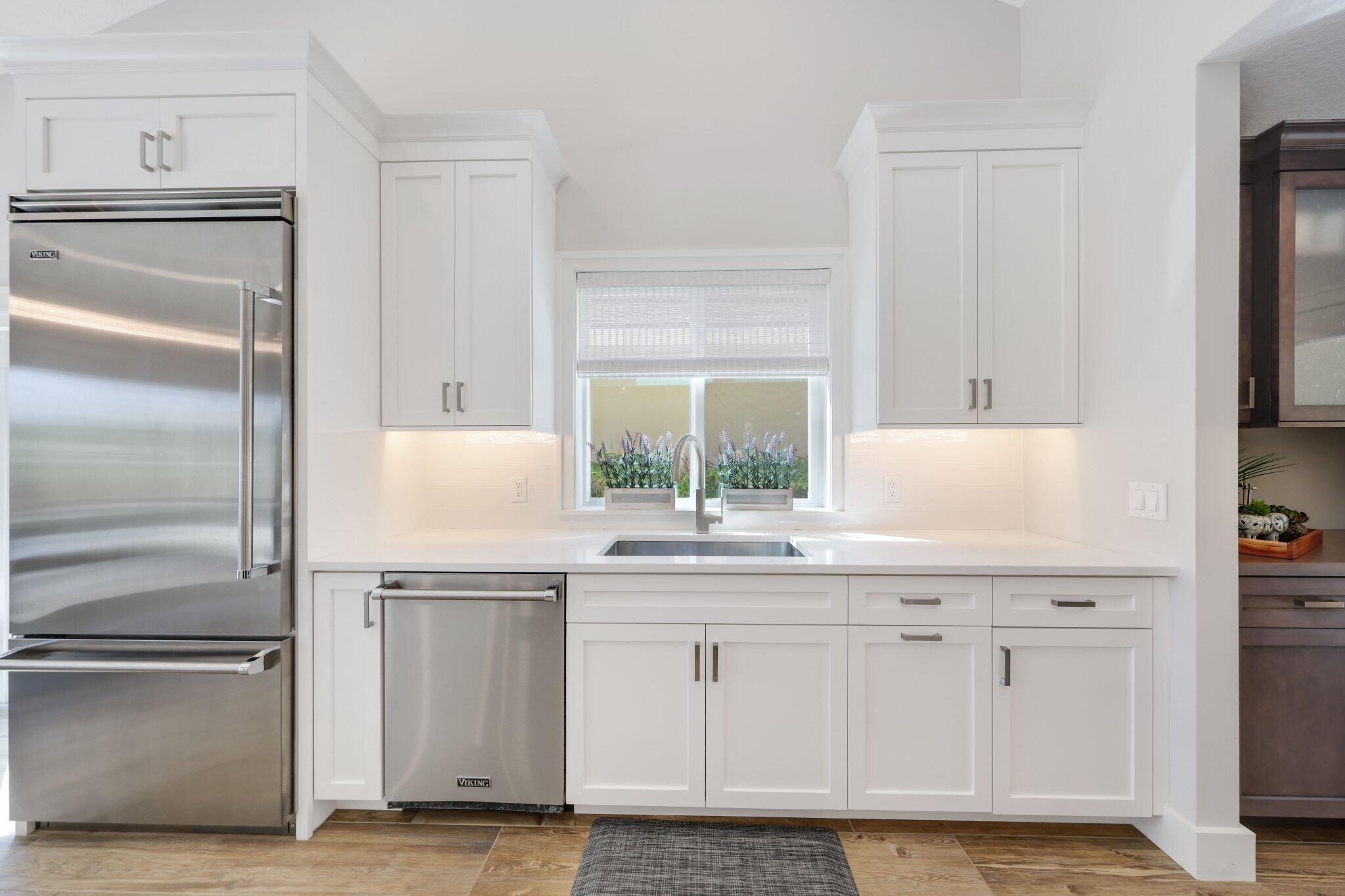 215 Ridge Road Jupiter, FL 33477 - Photo 11 of 43 a kitchen with white cabinets and a refrigerator