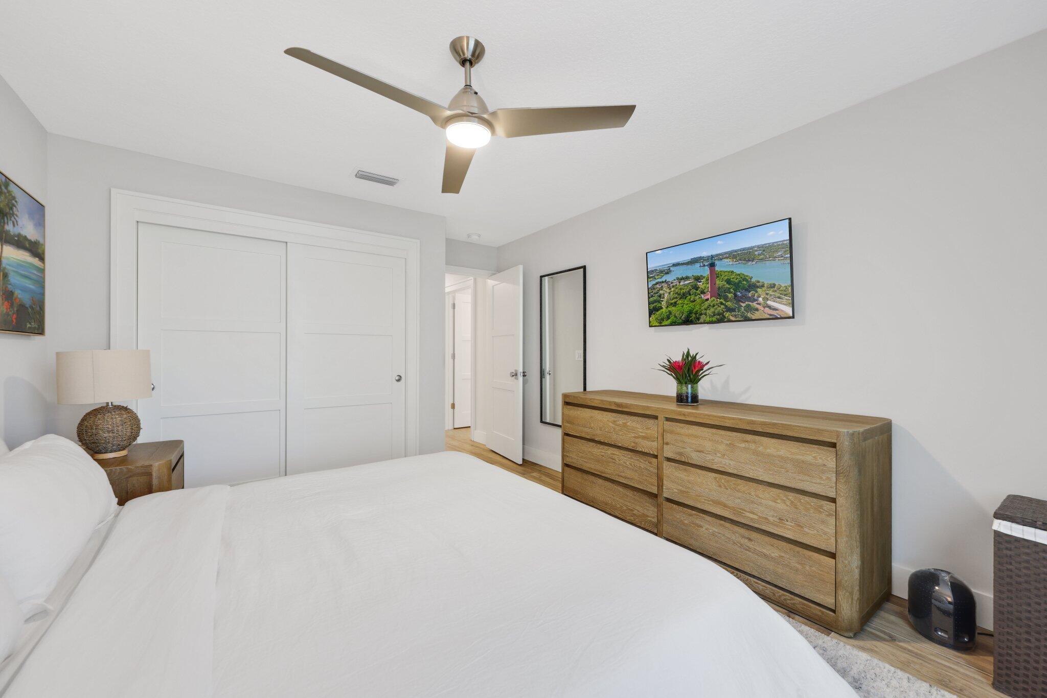 215 Ridge Road Jupiter, FL 33477 - Photo 29 of 43 a bedroom with a bed and a chandelier