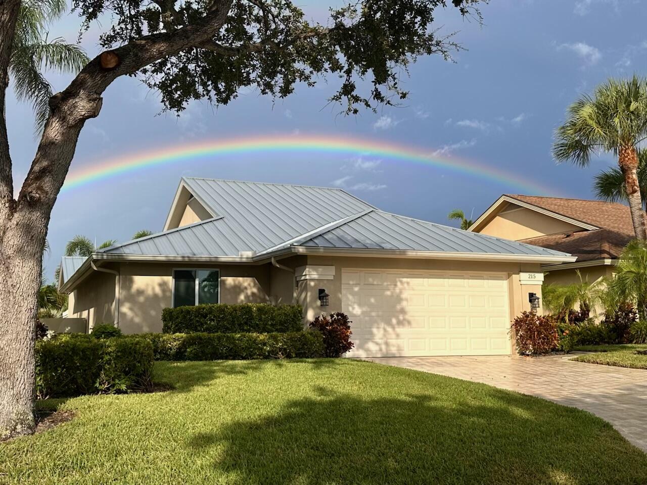 215 Ridge Road Jupiter, FL 33477 - Photo 3 of 43 a front view of a house with a garden