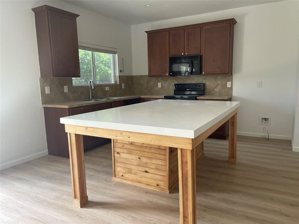 a kitchen with a wooden floor and a sink