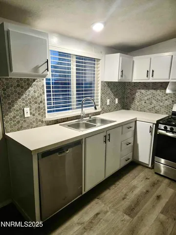a kitchen with white cabinets and sink