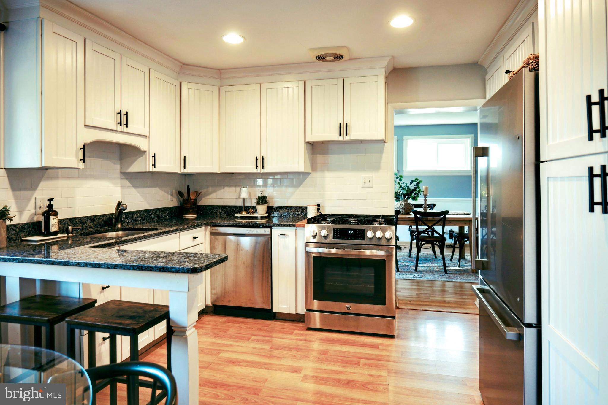 7323 Inzer Street Springfield, VA 22151 - Photo 6 of 25 a kitchen with stainless steel appliances granite countertop a stove a sink and a refrigerator