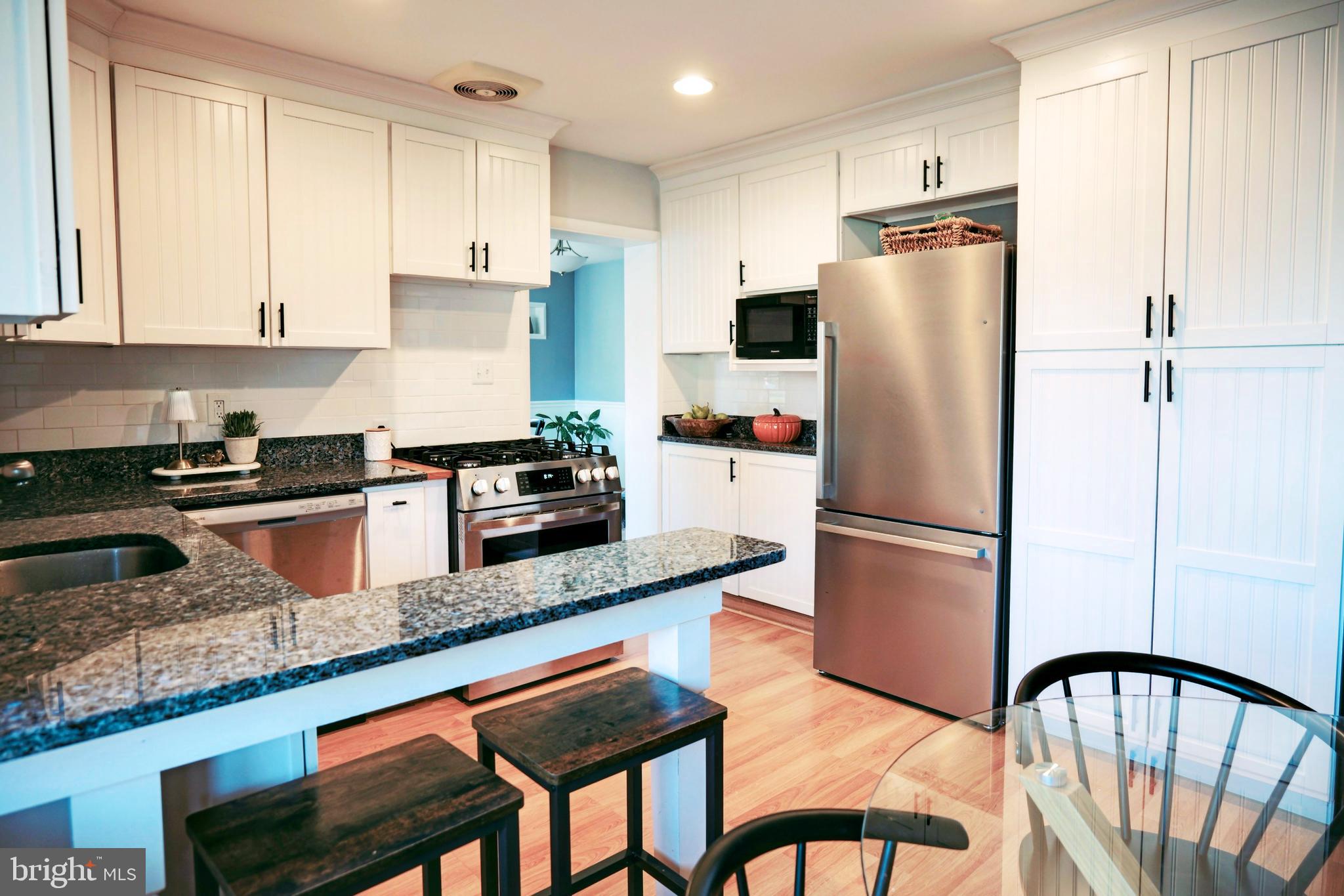 7323 Inzer Street Springfield, VA 22151 - Photo 7 of 25 a kitchen with stainless steel appliances granite countertop a refrigerator a stove a sink and white cabinets