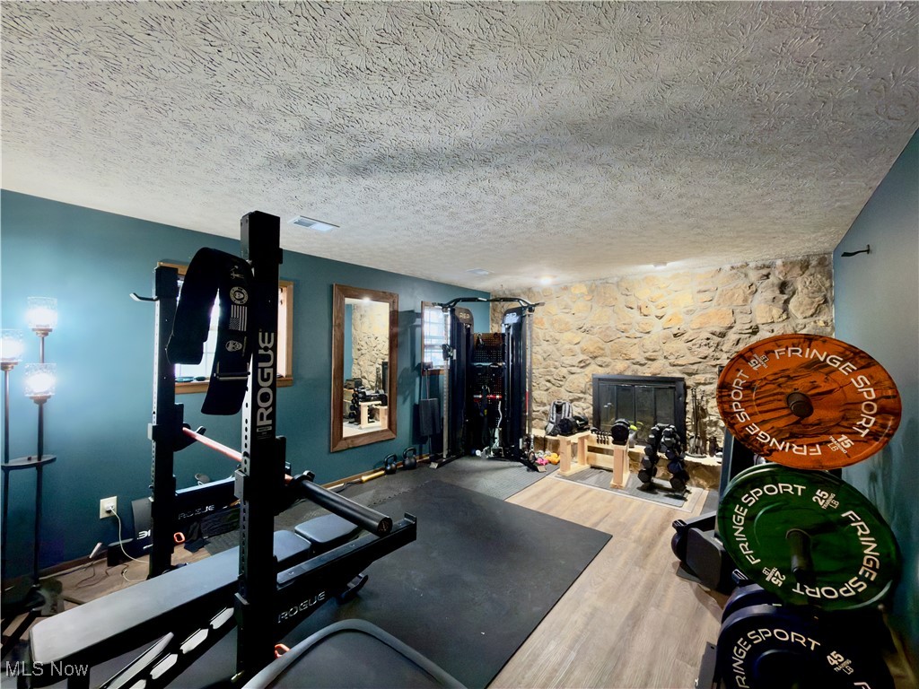 43 Romine Road Washington, WV 26181 - Photo 22 of 30 Exercise area with a textured ceiling and wood finished floors