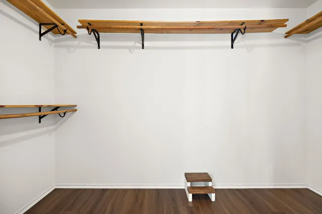 a view of a room with a bench and wooden floor