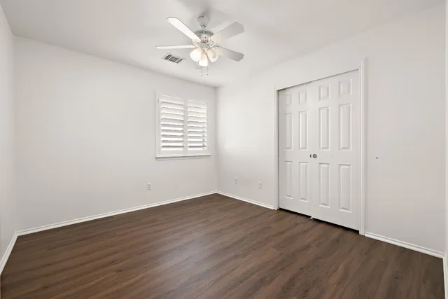 an empty room with wooden floor and window