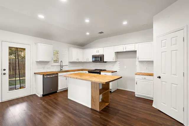 a kitchen with stainless steel appliances granite countertop a sink a stove and a refrigerator