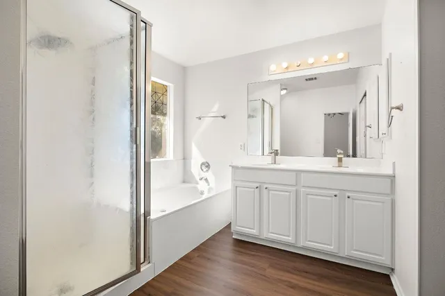 a spacious bathroom with a granite countertop sink mirror and a bathtub