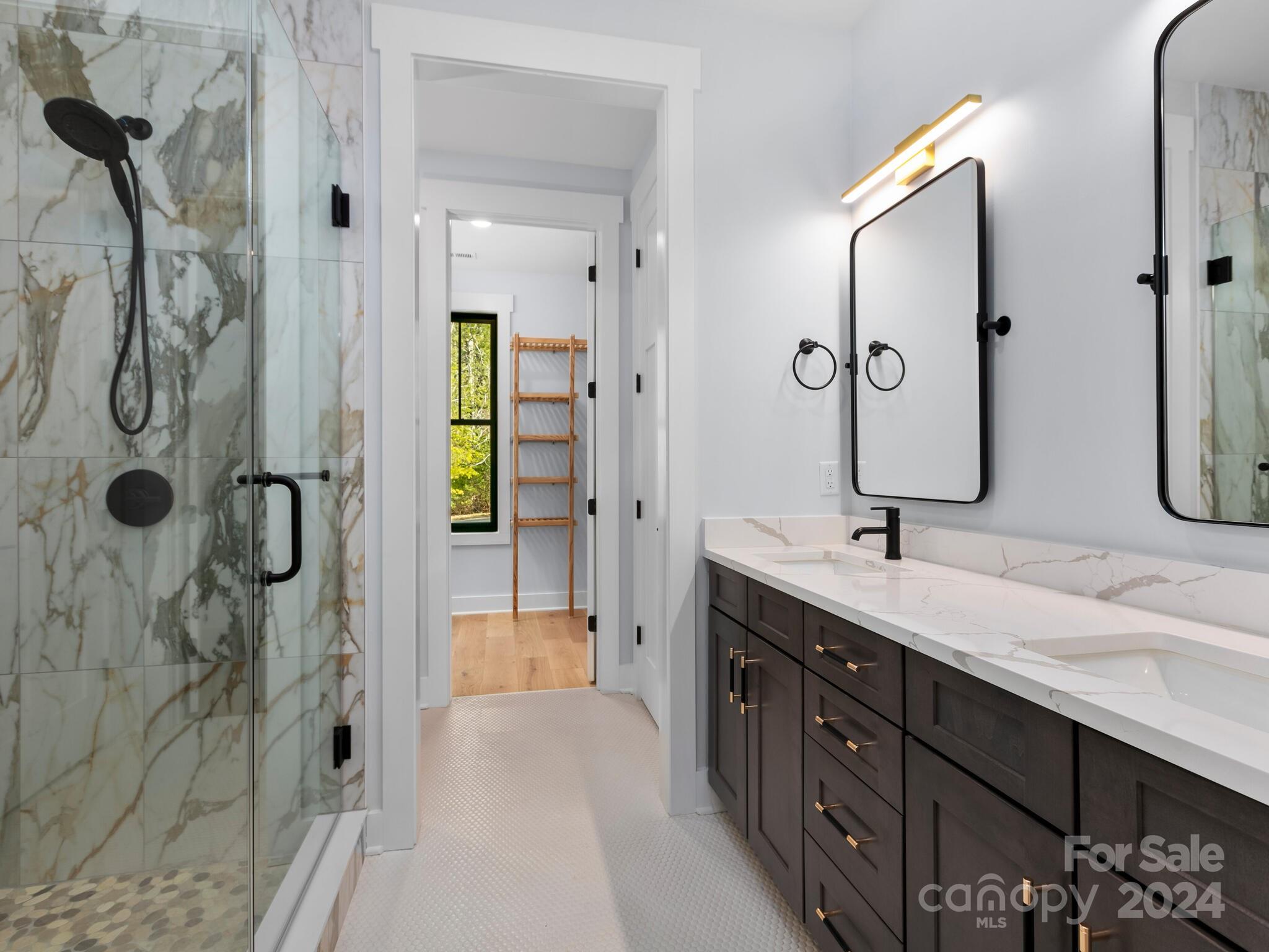 70 Reta Road Fairview, NC 28730 - Photo 11 of 22 a spacious bathroom with a double vanity sink a large mirror a bathtub and shower