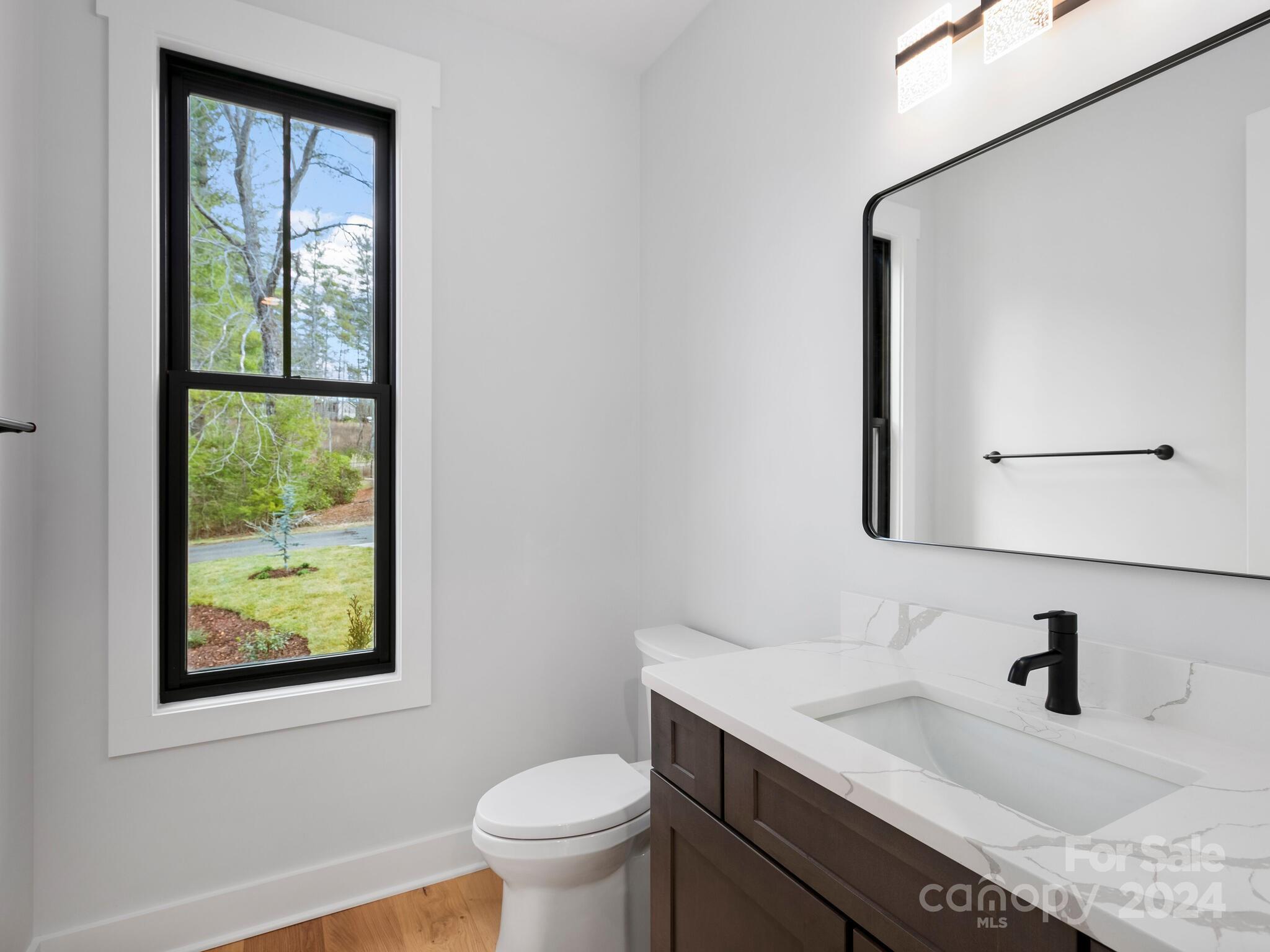 70 Reta Road Fairview, NC 28730 - Photo 13 of 22 a bathroom with a granite countertop sink mirror vanity and toilet