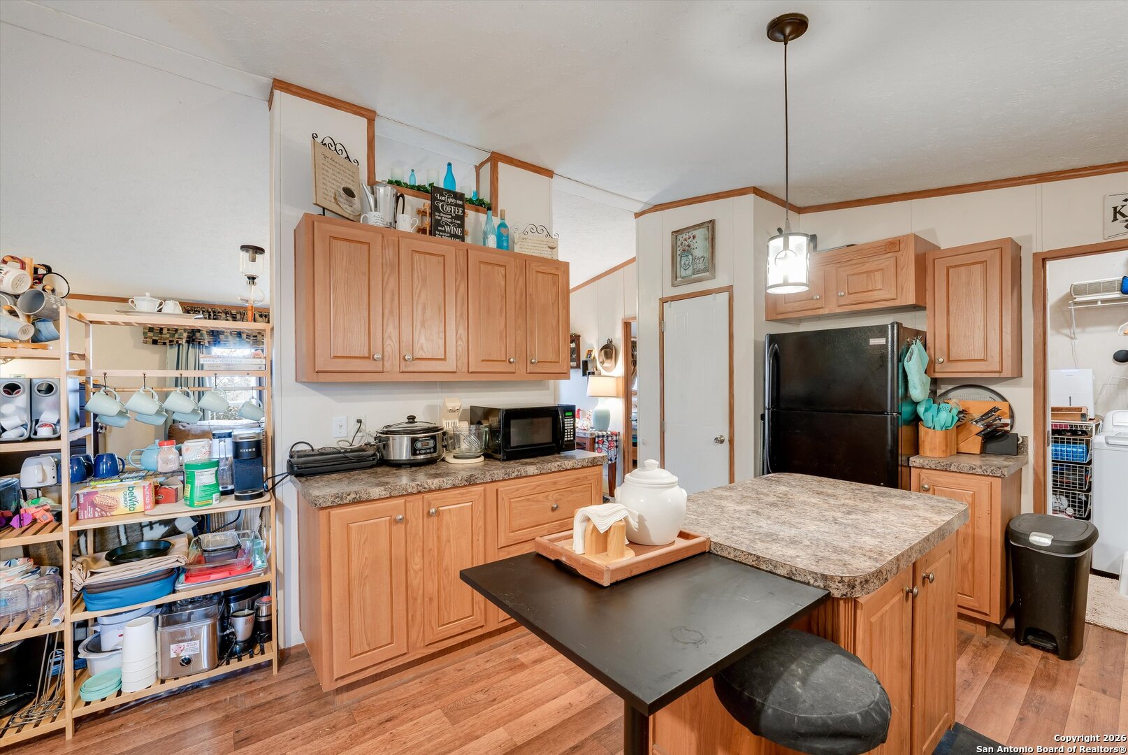 2760 Pioneer Road Seguin, TX 78155 - Photo 12 of 31 a kitchen with stainless steel appliances kitchen island granite countertop a table chairs in it and wooden floors