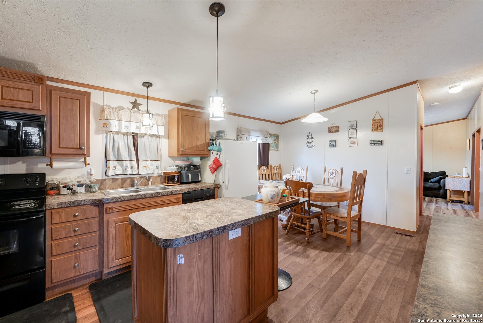 2760 Pioneer Road Seguin, TX 78155 - Photo 10 of 31 a kitchen with a stove a refrigerator a dining table and chairs with wooden floor
