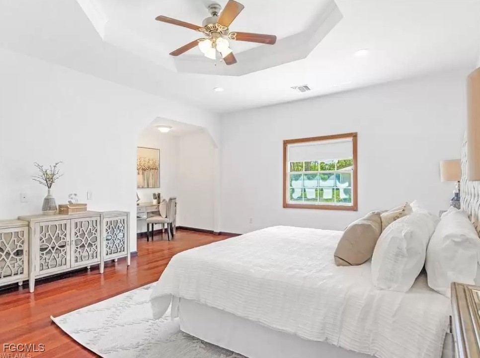 6343 Mark Lane Fort Myers, FL 33966 - Photo 13 of 37 a bedroom with a large bed and a chandelier