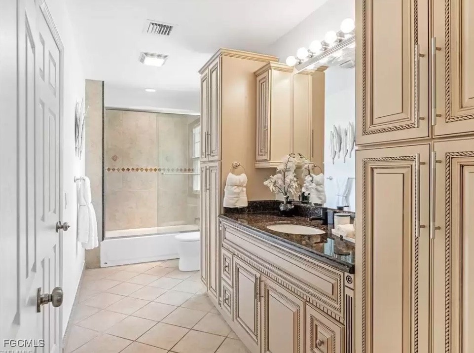 6343 Mark Lane Fort Myers, FL 33966 - Photo 26 of 37 a bathroom with a granite countertop sink a toilet and a glass door shower